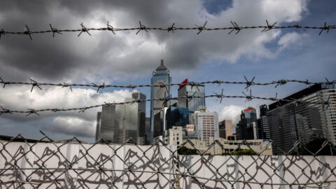 This photo taken on June 29, 2023 shows barbed wire fencing with the Wan Chai district in the background in Hong Kong.