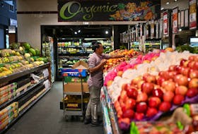 An employee stocks fruit at a specialty grocery store in Sydney, Australia, June 17, 2020. 