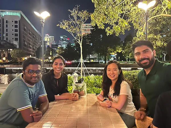 ="Kaushik and his team seated around a table outdoors"