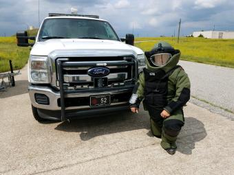officer in bomb squad body armor next to truck