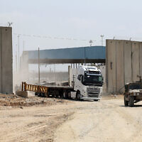 An Israeli military vehicle leads a truck in Beit Hanoun in the northern Gaza Strip during an operation to deliver humanitarian aid from Jordan to the coastal territory through the Erez Crossing, on May 1, 2024. (Jack Guez/ AFP)