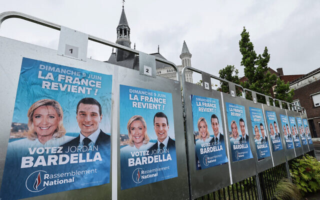 Electoral posters of National Rally (Rassemblement National) party with the pictures of Marine Le Pen (L) and Jordan Bardella are seen pasted on in Henin-Beaumont on June 10, 2024, a day after the European elections. (Denis Charlet/AFP)