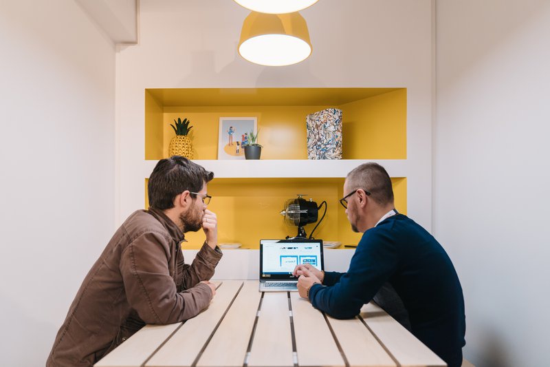 Un commerçant et un coach Google Ateliers Numériques travaillent sur un projet digital, dans un bureau au sein du basecamp.
