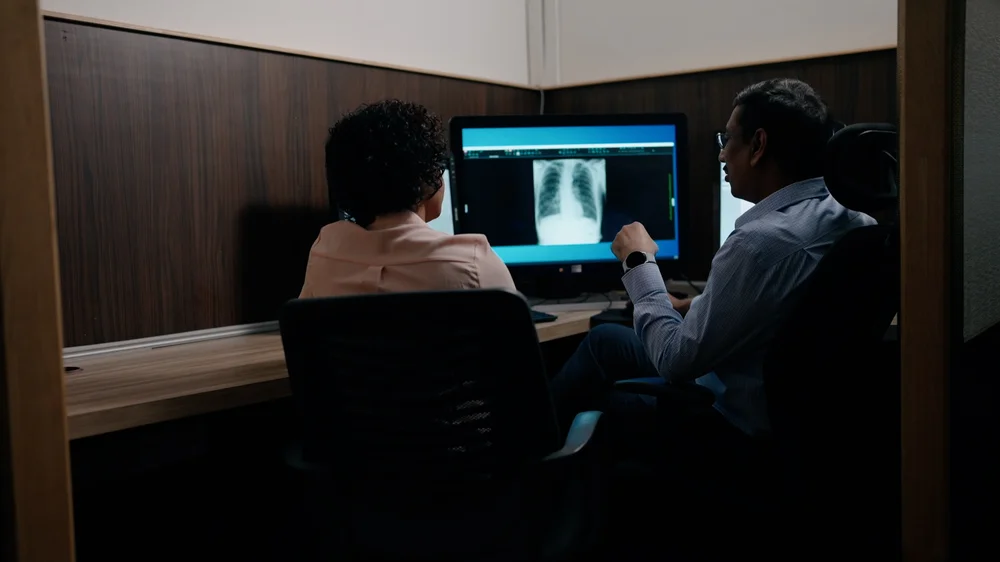 Image of two people looking at a chest x-ray scan.