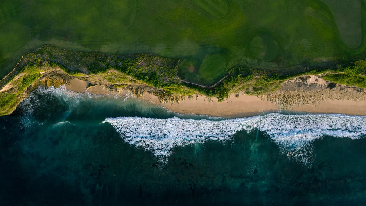 An aerial photo of a coastline with waves crashing