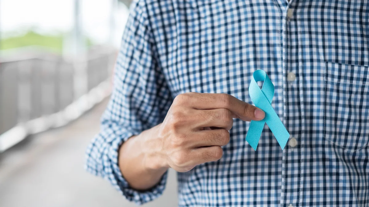 Man holding blue ribbon for National Prostate Cancer Awareness Month