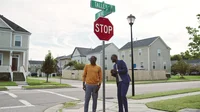 Two men stand at the intersection of two residential streets named Talley Avenue and Twine Circle