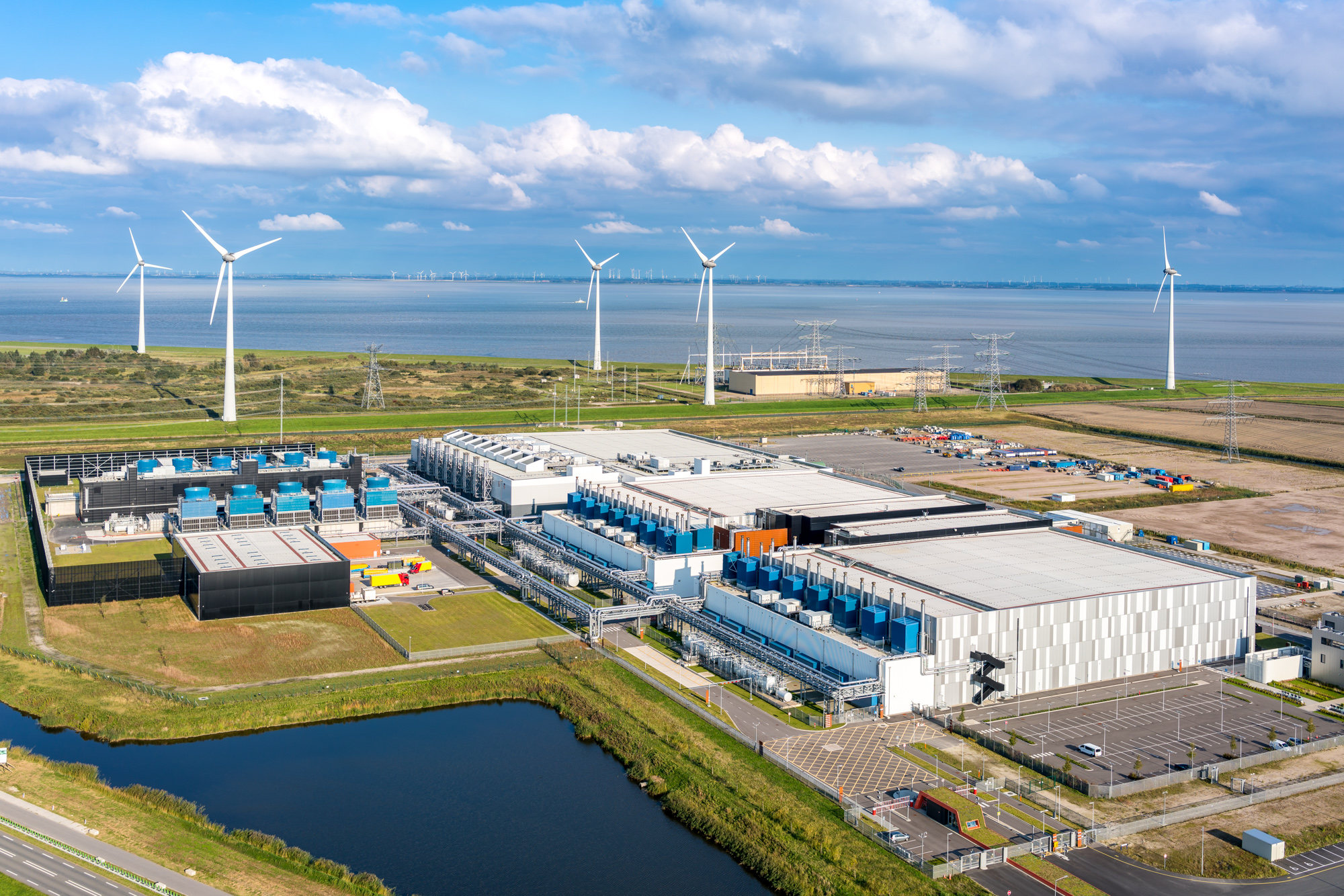 Aerial view of a data center with windmills in the background
