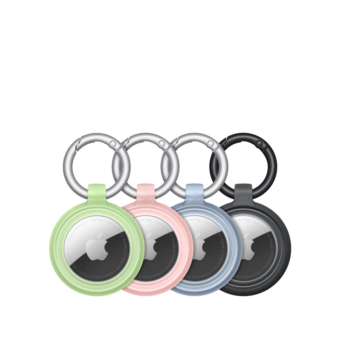 Cztery etui OtterBox Lumen Series w kolorach zielonym, różowym, niebieskim i czarnym z bezpiecznie umieszczonymi w nich AirTagami; w środku widoczne logo Apple.