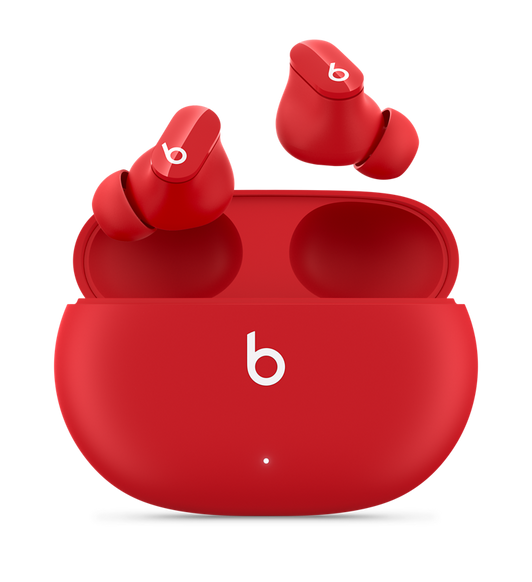 BeatsレッドのBeats Studio Buds – ワイヤレスノイズキャンセリングイヤフォン。便利な充電ケースの上に配置され、Beatsのロゴが見えている。