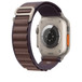Dây Quấn Alpine Màu Xanh Indigo được thể hiện cùng cảm biến sức khỏe và vùng sạc ở mặt sau của Apple Watch Ultra