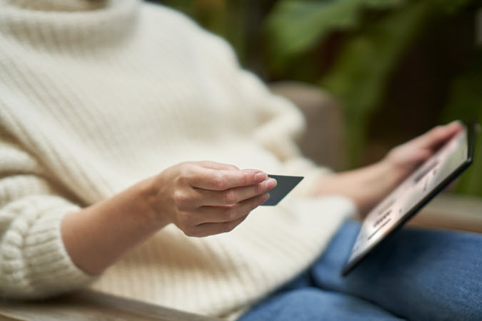 Žena drži kreditnu karticu i prijenosno računalo