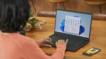 Wanita bekerja pada laptop yang menjalankan Windows 11