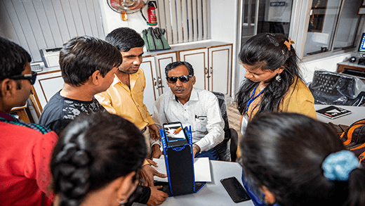 En lärare visar hur du använder tekniska hjälpmedel för att läsa blindskrift på ett yrkescenter för blinda i Indien.