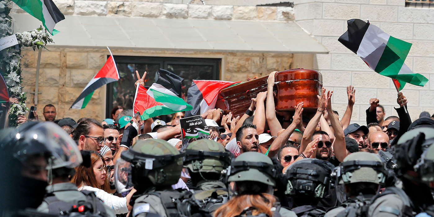 Violence erupts between Israeli security forces and Palestinian mourners carrying the casket of slain  Al-Jazeera journalist Shireen Abu Akleh out of a hospital, before being transported to a church and then her resting place, in Jerusalem, on May 13, 2022. - Abu Akleh, who was shot dead on May 11, 2022 while covering a raid in the Israeli-occupied West Bank, was among Arab media's most prominent figures and widely hailed for her bravery and professionalism. (Photo by Ahmad GHARABLI / AFP) (Photo by AHMAD GHARABLI/AFP via Getty Images)