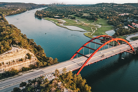 Vue aérienne d’une rivière et d’un pont à Austin (Texas), avec la ville en arrière-plan.