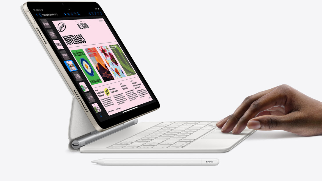 Vista lateral del iPad Air con la app Keynote abierta. Está acoplado a un Magic Keyboard y hay una mano apoyada en el trackpad y un Apple Pencil al lado.