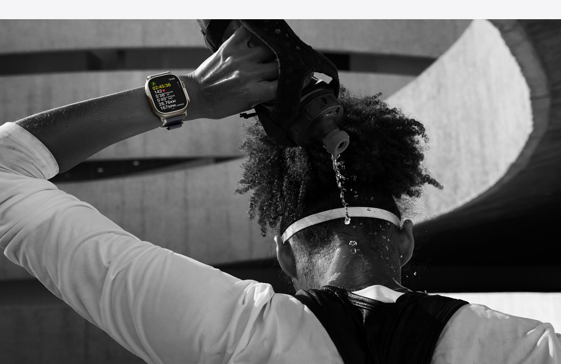 一位戴著 Apple Watch Ultra 2 的運動員將水倒在頸後。