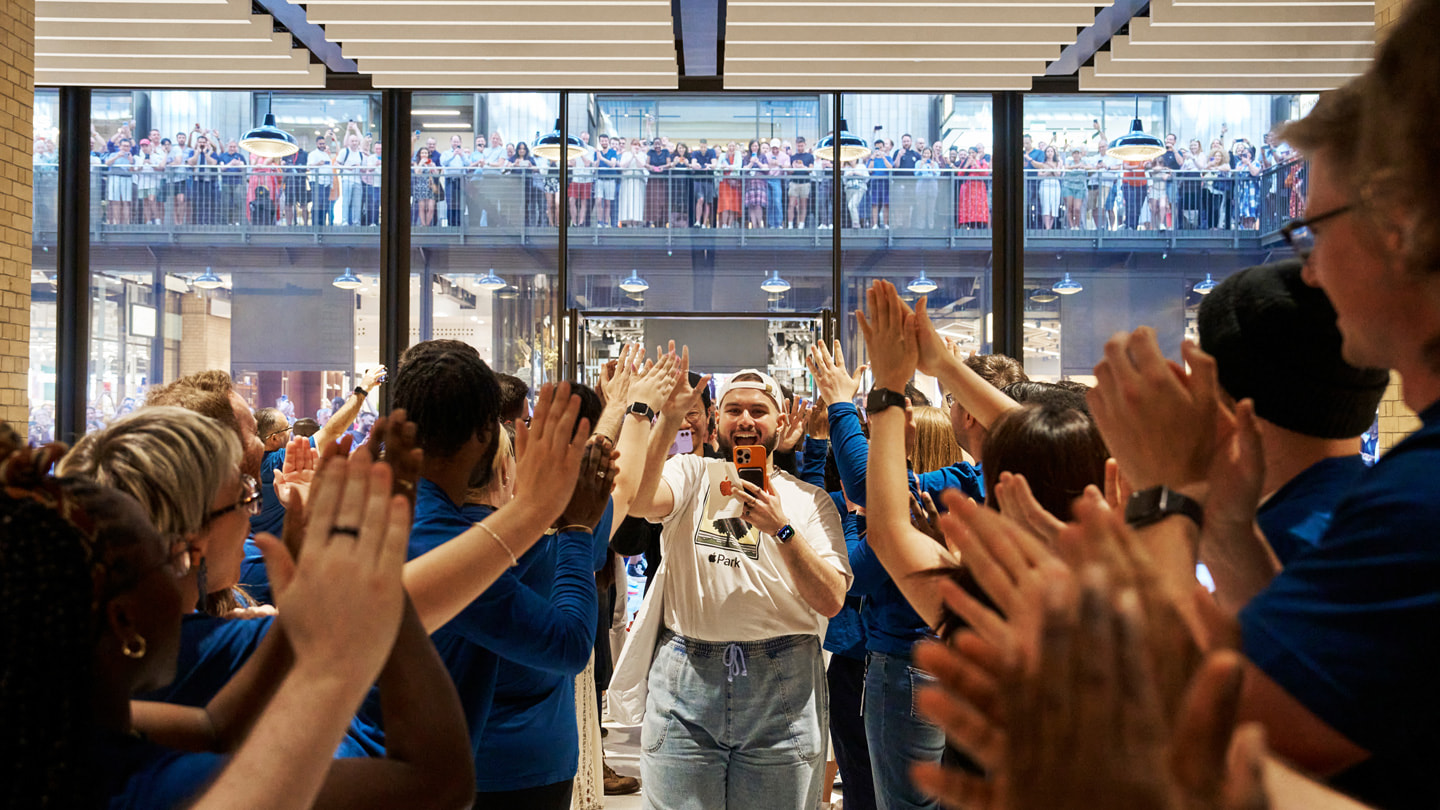Medewerkers applaudisseren voor de eerste bezoekers van Apple Battersea. 