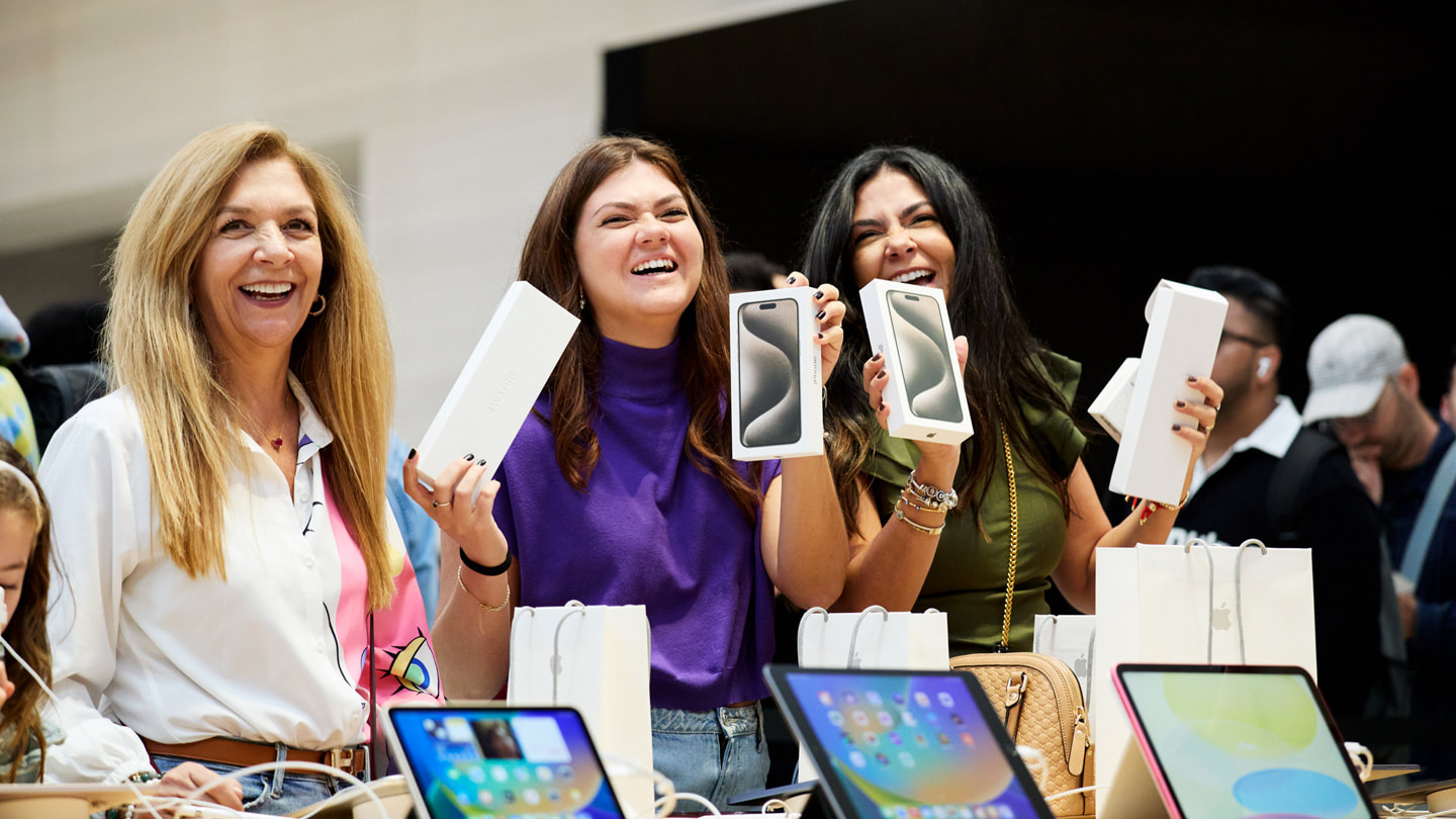 Glückliche Kundinnen zeigen ihre neuen iPhone 15 Modelle im Apple Fifth Avenue in New York City.