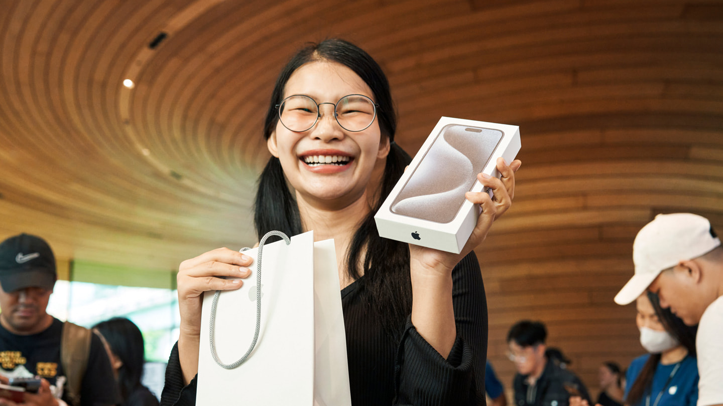 Khách hàng khoe điện thoại iPhone 15 Pro Max mới tại cửa hàng Apple Central World ở Bangkok.