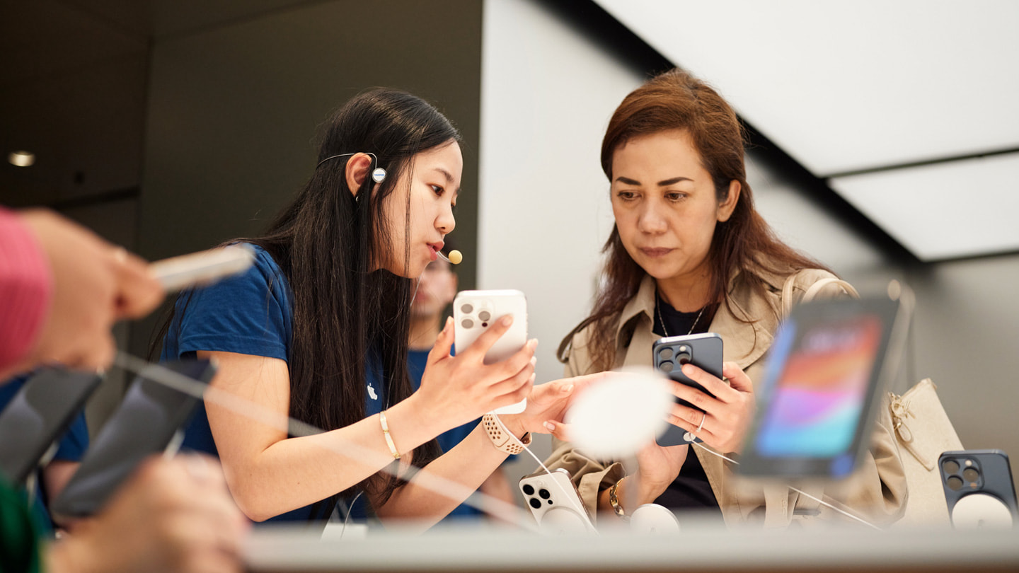 Ein Apple Teammitglied hilft einer Kundin beim Kauf des iPhone 15 Pro im Apple Sydney, Australien.