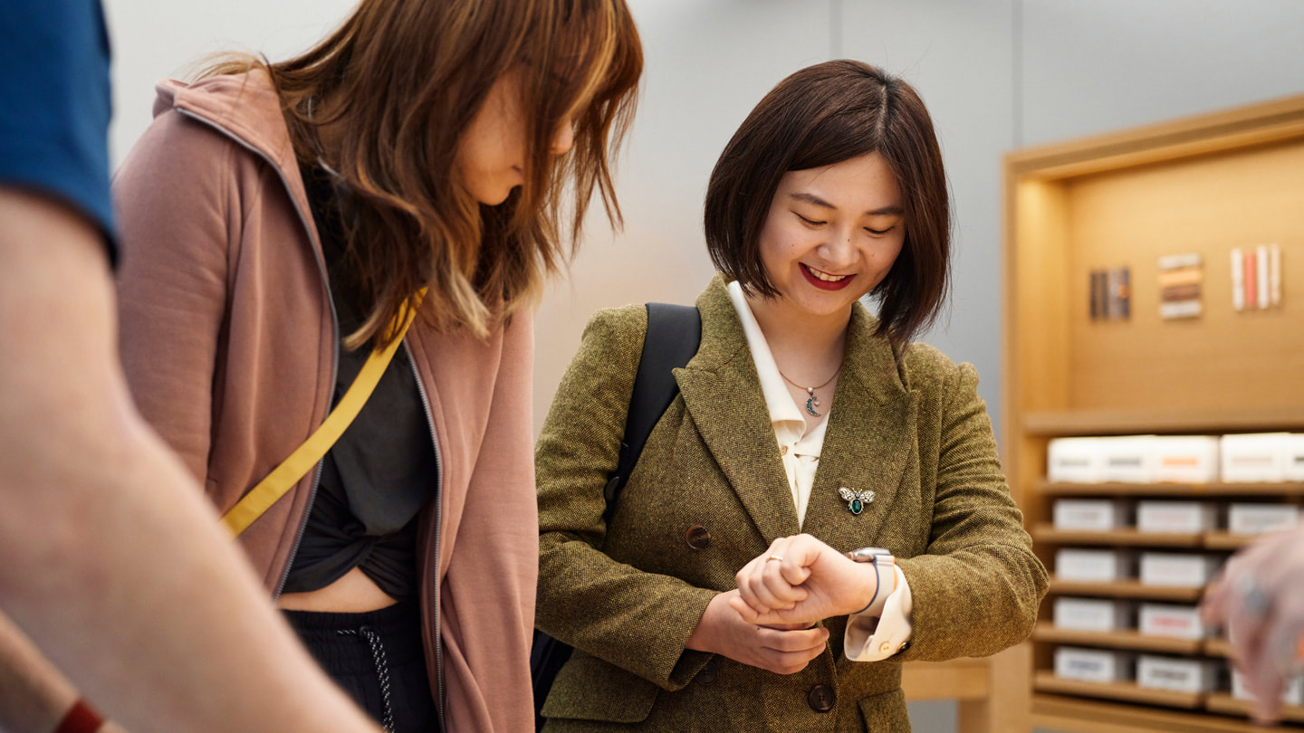Hai khách hàng đang đeo thử Apple Watch Ultra 2 bên trong cửa hàng Apple Sydney, Úc.