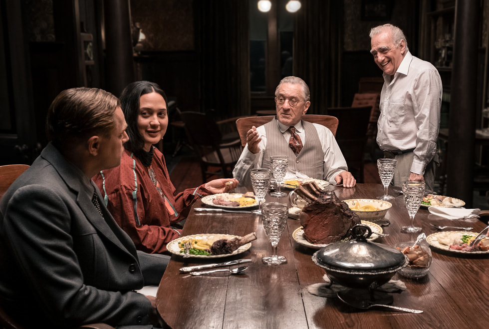 “Dolunay Katilleri” filminden bir sahne arkası görüntüsünde yemek masasının etrafında Leonardo DiCaprio, Lily Gladstone, Robert De Niro ve Martin Scorsese.