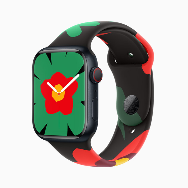 Eine Apple Watch Series 9 mit dem neuen Armband und Zifferblatt der Black Unity Collection; auf diesem Bild hat das Zifferblatt eine grosse grüne Blüte mit einer roten und gelben Mitte.