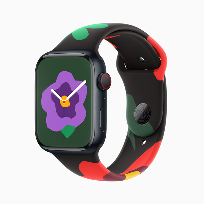 Eine Apple Watch Series 9 mit dem neuen Armband und dem Zifferblatt der Black Unity Collection; auf diesem Bild zeigt das Zifferblatt eine kleinere lila Blume.