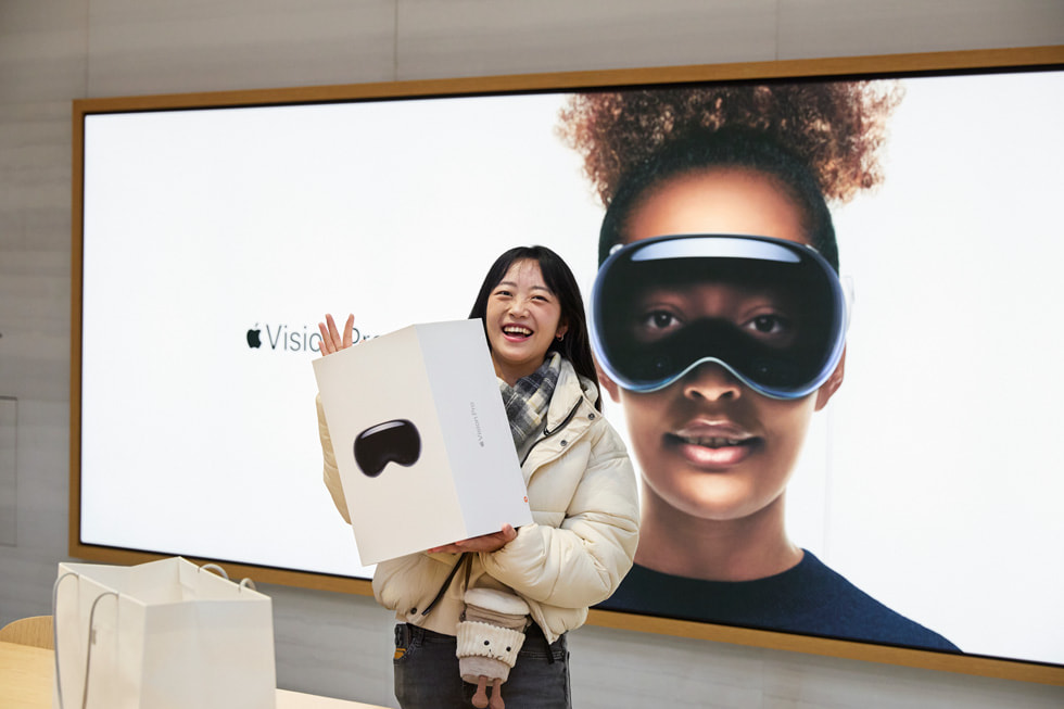 A young woman posing with her Apple Vision Pro purchase.