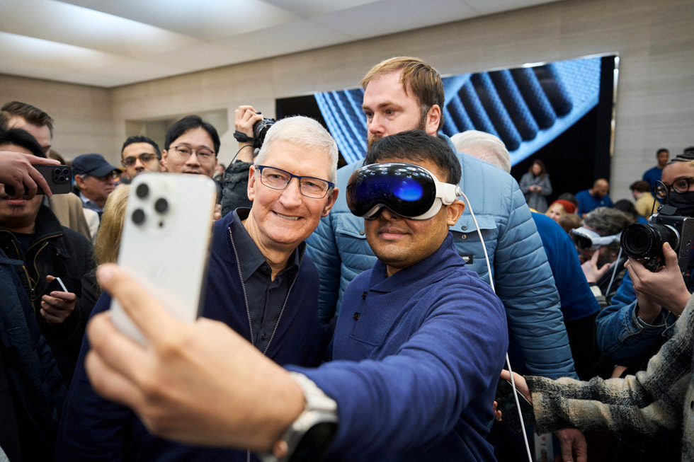 Tim Cook taking a selfie with an Apple Vision Pro customer.