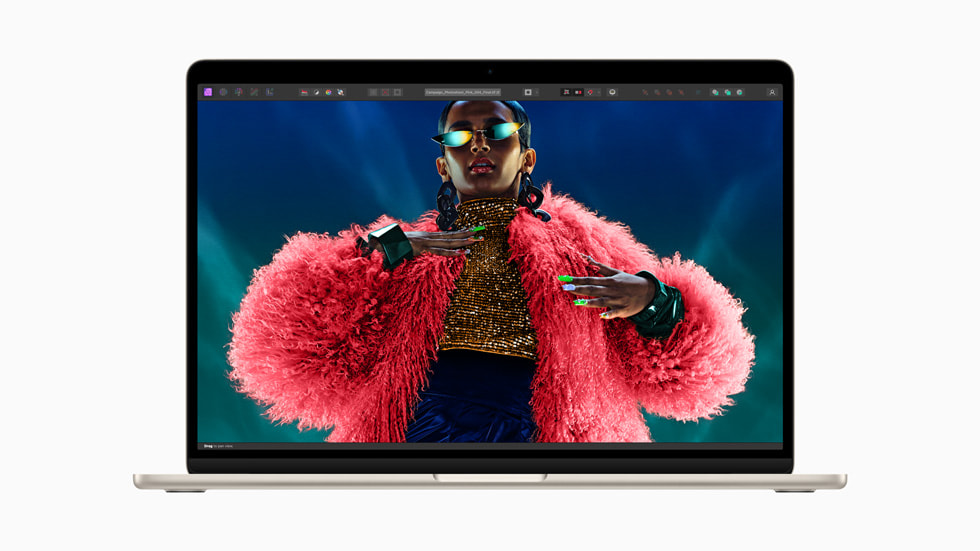 Na novém MacBooku Air se zobrazuje fotka osoby v zářivě červeném chlupatém kabátu.