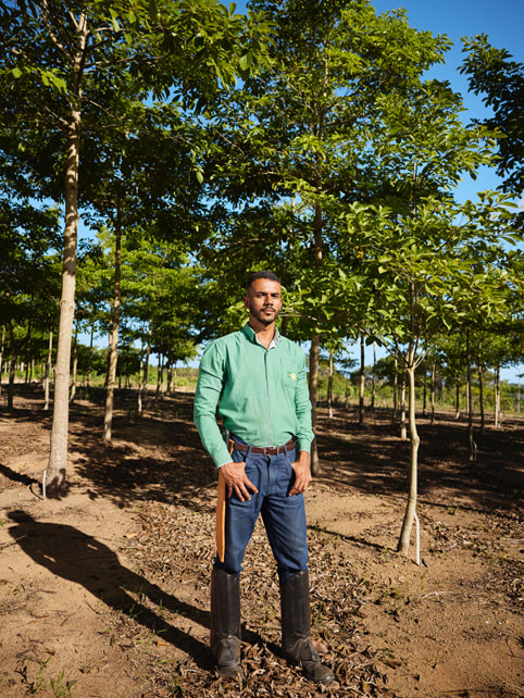 Victor Leon Rocha Araújo ve vysokých botách uprostřed řady stromů v Atlantickém lese