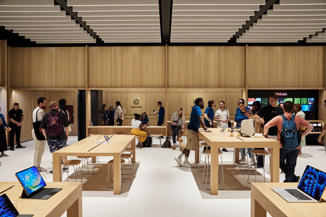 Interiér kamenné prodejny Apple Store se zákazníky a zaměstnanci