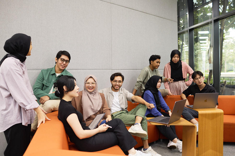 Dokuz Apple Geliştirici Akademisi öğrencisi bir sınıf ortamında gösteriliyor.