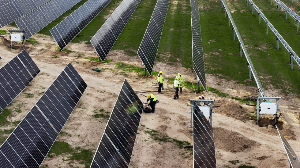 田野裡可見太陽能電池板和工人。