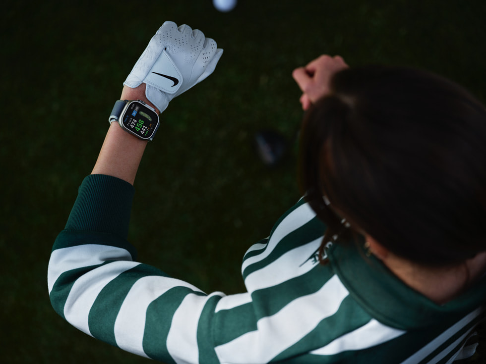 Bild ovanifrån av en golfare som tittar på sin Apple Watch.