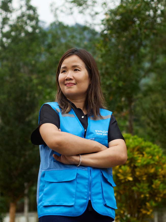 Portrait de Chu Thanh Hoa, se tenant debout en extérieur et portant une veste Gravity Water bleue.