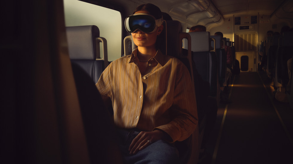 Hình ảnh một người đeo Apple Vision Pro trên xe lửa.