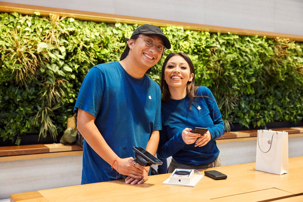 Hai nhân viên tại Apple Park Fifth Avenue hỗ trợ thanh toán cho một khách hàng. 