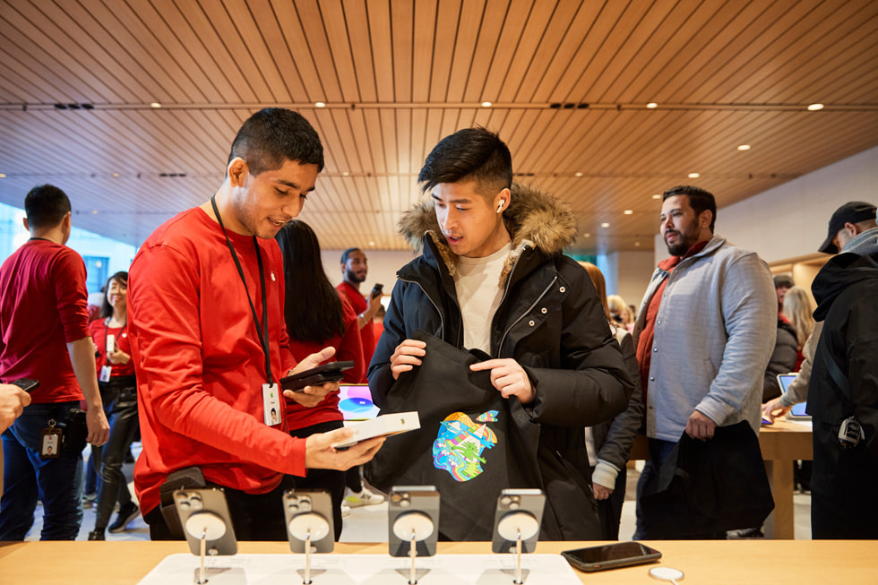 Một thành viên đang hỗ trợ khách hàng mua iPhone 14 Pro trong Apple Pacific Centre tại Vancouver, Canada.