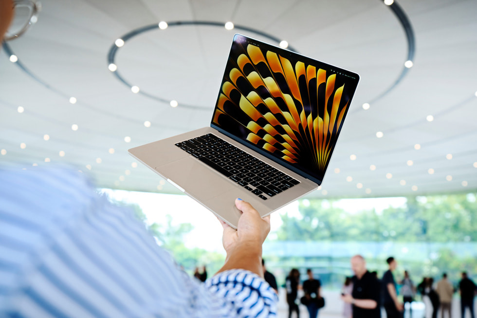 Účastník konference WWDC drží v Apple Parku nový 15palcový MacBook Air.