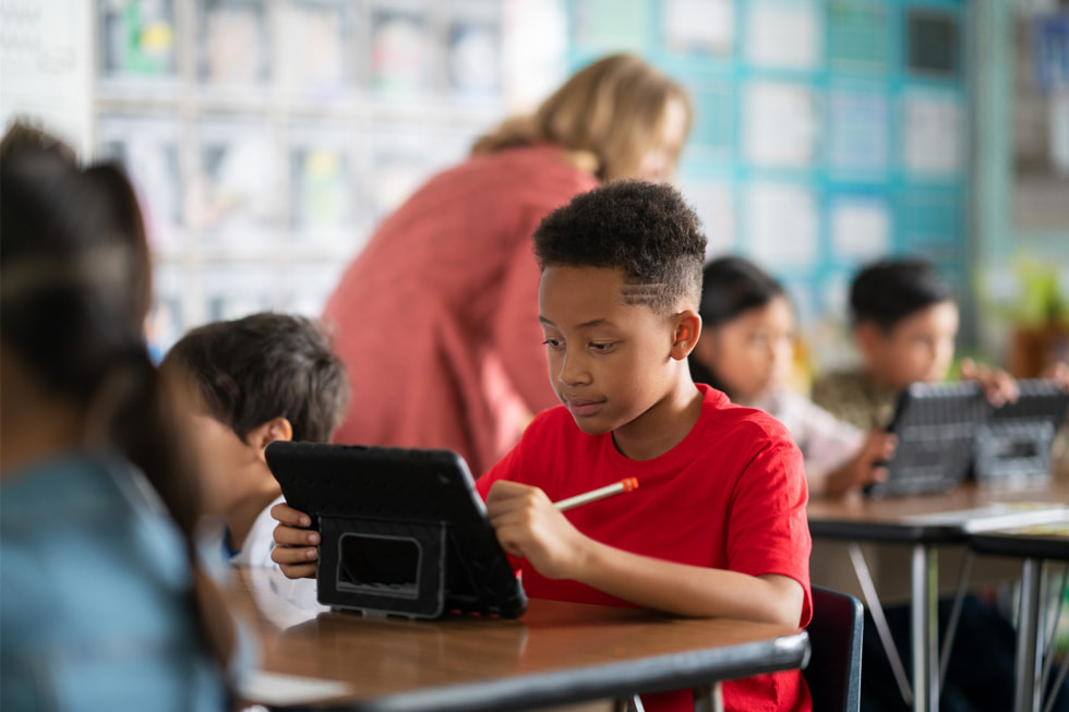 Downey Unified 學區的一名年輕學生在課堂上使用 iPad。