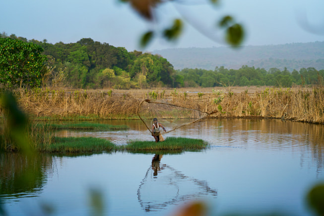 Hindistan’ın Maharashtra eyaletinde, mangrov sıralı bir nehirdeki üç kişi.