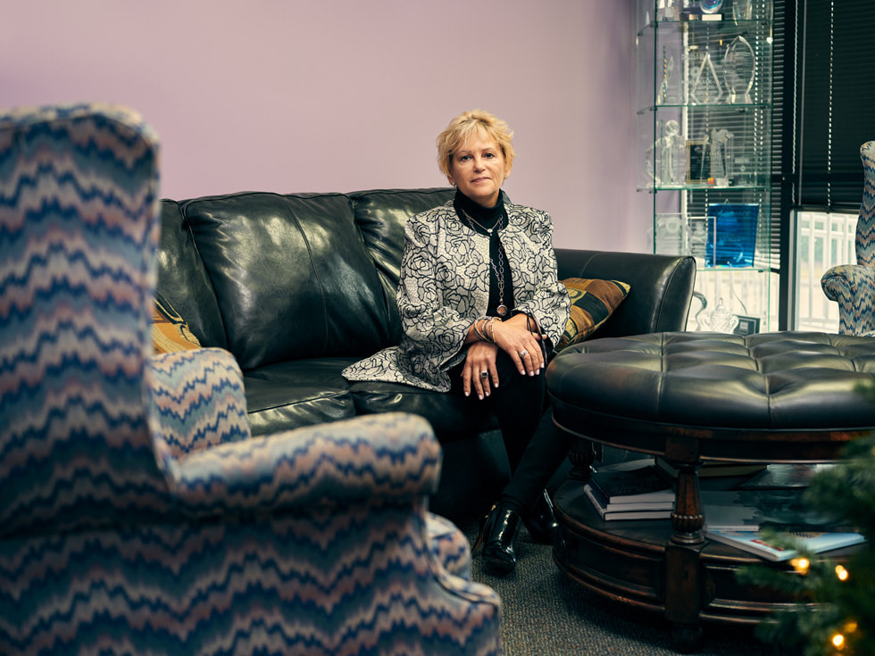 Betty Manetta, Argent Associates’ president and CEO, sitting on a couch inside her office.