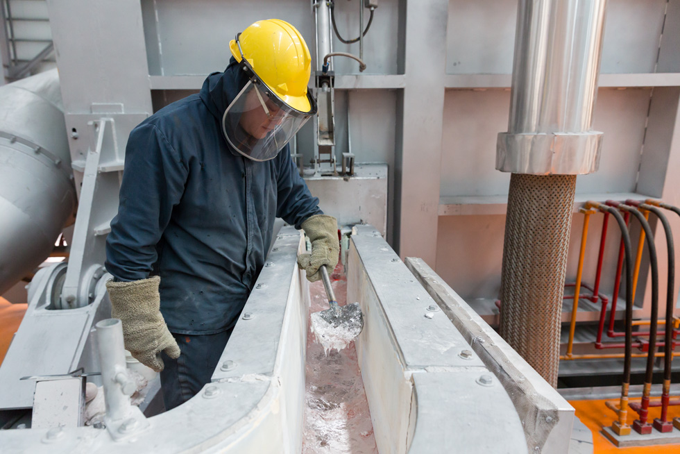 一家鋁金屬製造廠的一名工人在監控冶煉過程。