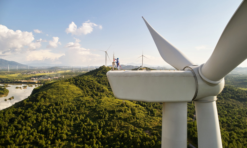 지상 수백 피트 높이에서 풍력 발전기를 수리하는 기술자의 모습.