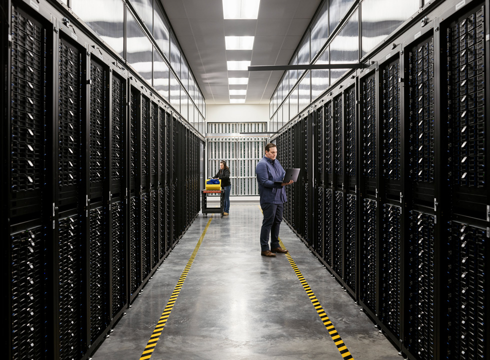 Apple 데이터센터 서버실에 있는 두 직원의 모습.