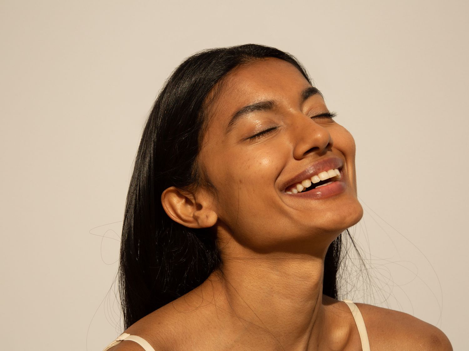 Woman smiling with glowing skin in sunlight